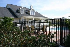 Home swimming pool in Shreveport surrounded by a wrought iron fence